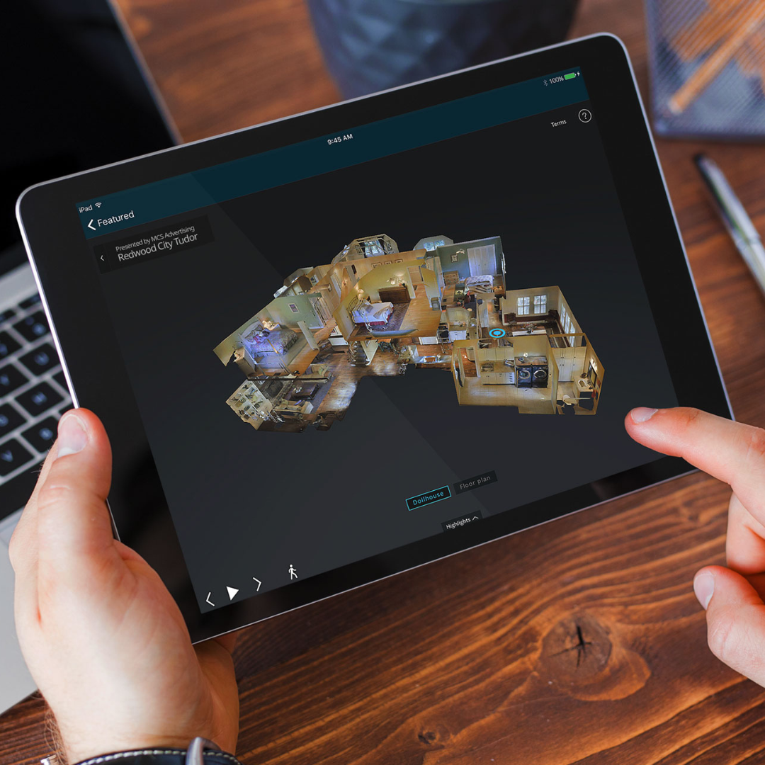 Une personne regarde sa tablette et l'utilise pour regarder en 3D un bien immobilier avec une visite virtuelle matterport